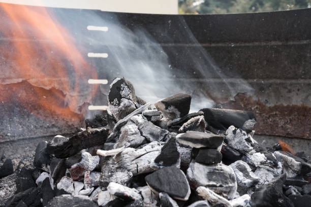 istock Charcoal burning with smoke in a barbecue grill. 1046470534