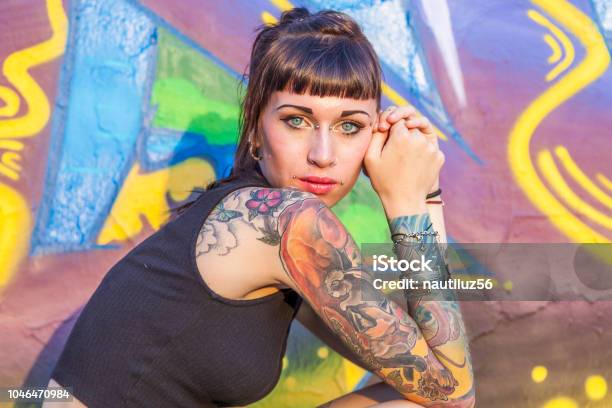 Photo libre de droit de Femme Rebelle Tatoué Qui Pose Contre Un Mur banque d'images et plus d'images libres de droit de Tatouage - Tatouage, Femmes, Piercing