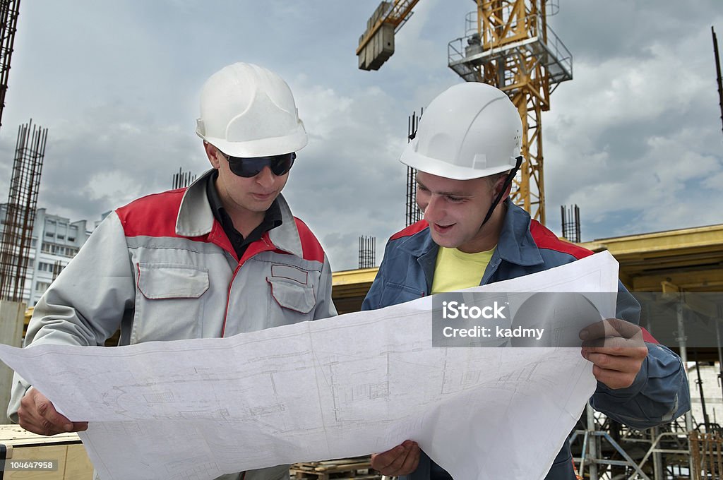 Ingenieros de constructores en la construcción del sitio - Foto de stock de Accesorio de cabeza libre de derechos