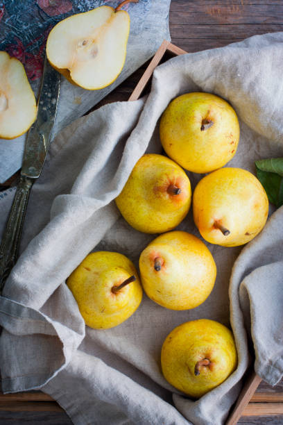 istock Chopped fresh yellow pear on a wooden board, top view, selective focus Fruit background. 1046482814