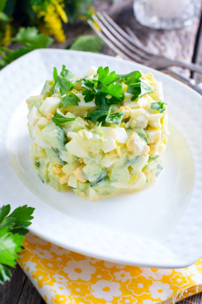 istock Fresh salad with cucumber, celery and eggs on a white porcelain plate, selective focus 1046488294