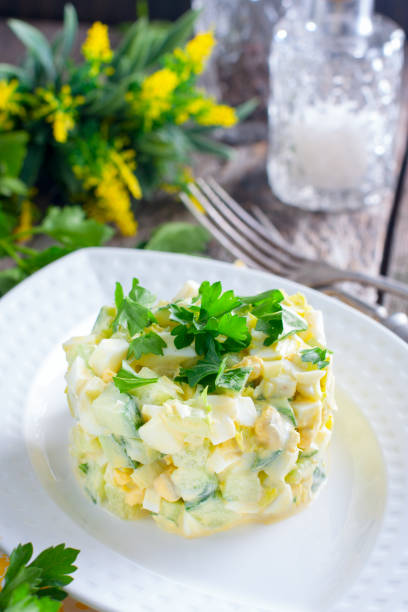 istock Fresh salad with cucumber, celery and eggs on a white porcelain plate, selective focus 1046488298
