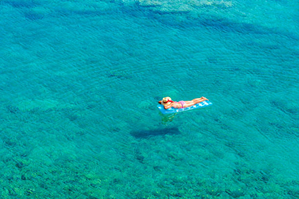 Women is sunbathing on the seabed.