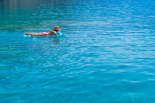 Women is sunbathing on the seabed.