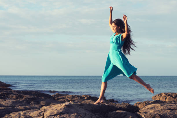 istock Woman jumping on the cliffs beside the sea 1046505108