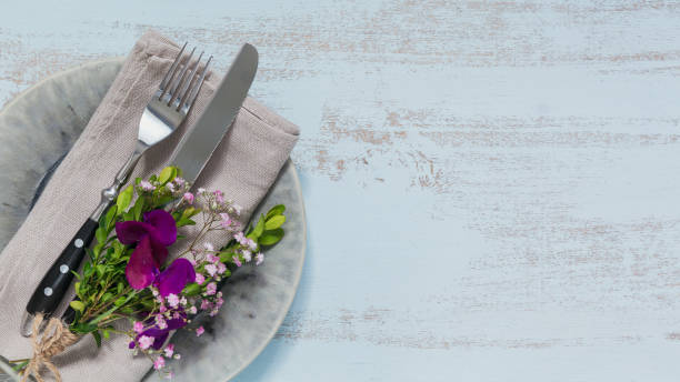 istock Rustic table setting with purple flowers on light wooden table. 1046511142