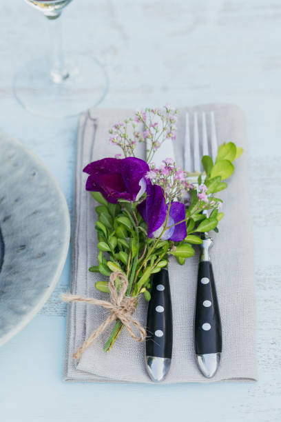istock Rustic table setting with purple flowers on light wooden table. 1046511152