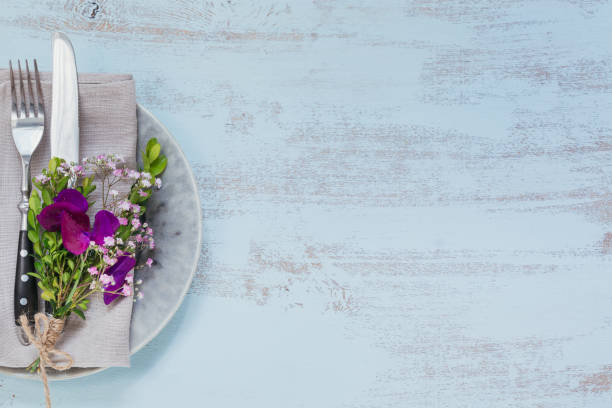 istock Rustic table setting with purple flowers on light wooden table. 1046511166