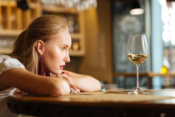 Sad young woman wanting to drink alcohol stock photo