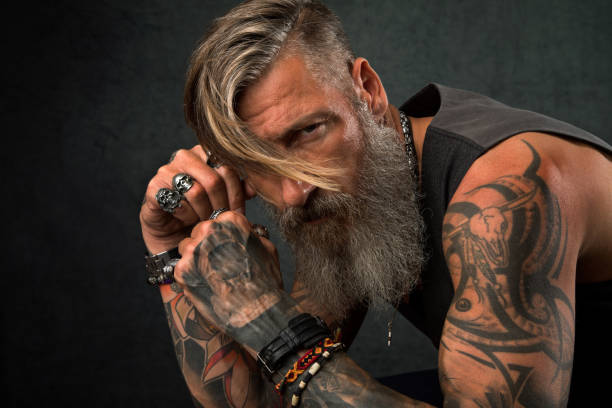 Portrait of a cool biker in the studio Portrait of a cool biker in the studio shoulder tattoo designs for men stock pictures, royalty-free photos & images