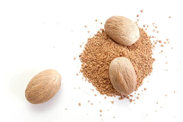 Whole and grated nutmeg isolated on white background