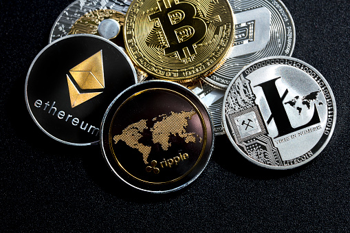 izmir, Turkey - September 28, 2018 Close up ethereum ripple litecoin bitcoin dash coins shot in metallic black background in studio
