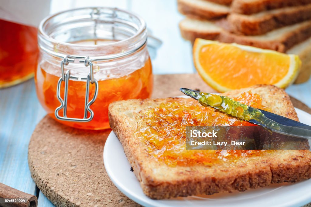 Slices of toasted bread with orange jam for breakfast Slices of toasted bread with orange jam and glass jar for breakfast Marmalade Stock Photo