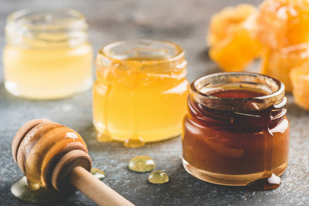 selectie van honing in kleine honing potten - glas serviesgoed fotos stockfoto's en -beelden