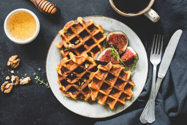 Whole wheat waffles, honey and coffee Whole wheat waffles, honey and coffee on black concrete background. Table top view of tasty breakfast walnut cookies stock pictures, royalty-free photos & images