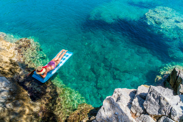 Women is sunbathing on the seabed.