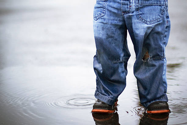 child standing in puddle stock photo