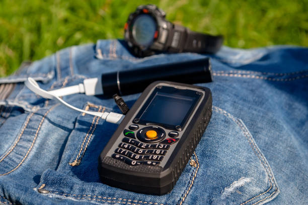 istock A mobile phone and a power bank on a jeans on background clock. 1046532502