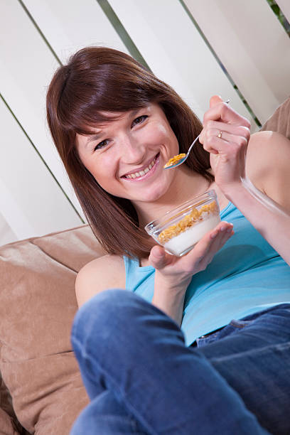 istock woman eating corn flakes on sofa 104653467