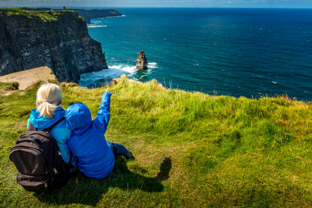 femme et garçon regardant les falaises de moher en irlande - republic of ireland cliffs of moher landscape cliff photos et images de collection