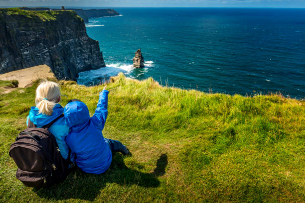 donna e ragazzo guardando cliffs of moher in irlanda - cliffs of moher cliff republic of ireland sea foto e immagini stock