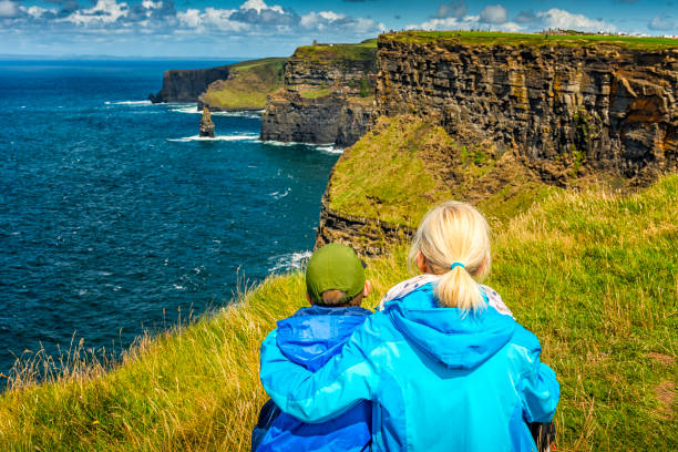 woman and boy looking at cliffs of moher in ireland - republic of ireland cliffs of moher panoramic cliff imagens e fotografias de stock