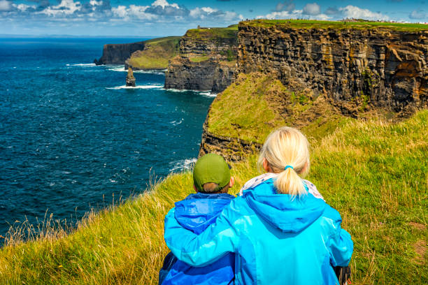 женщина и мальчик, глядя на скалы мохер в ирландии - republic of ireland cliffs of moher landscape cliff стоковые фото и изображения