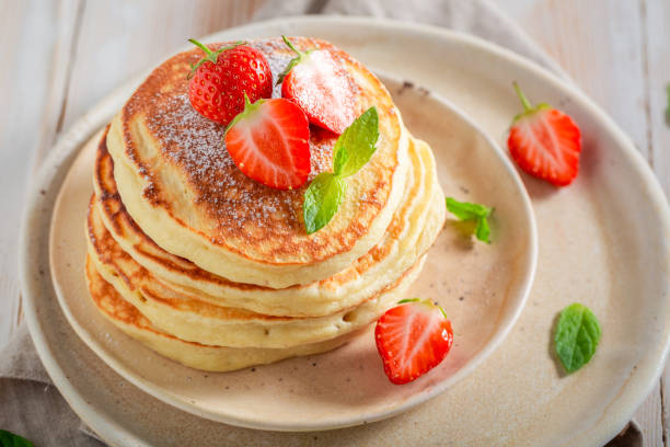 istock Yummy american pancakes with powdered sugar and strawberries 1046544196