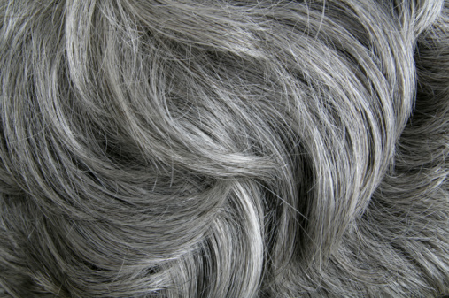 Close-up of a woman getting her hair dyed in a hair salon.