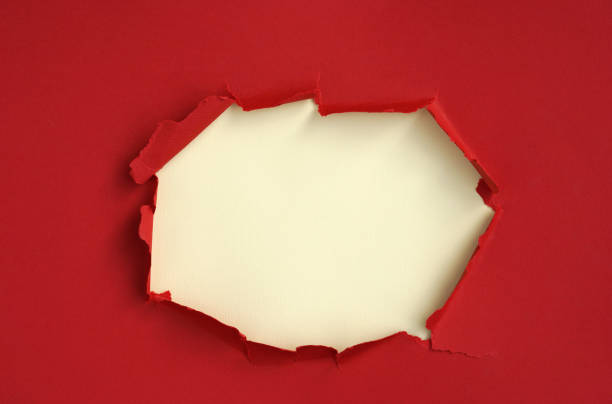 istock Wrinkle ripped torn red paper with hole in center poster backdrop empty backgrounds space for text 1046548978