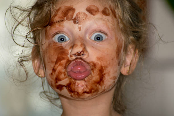 kleines mädchen gesicht mit schokoladeneis - child chocolate ice cream human mouth stock-fotos und bilder