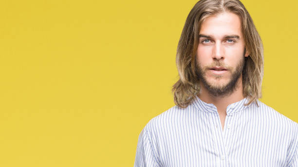 istock Young handsome man with long hair over isolated background with serious expression on face. Simple and natural looking at the camera. 1046560222