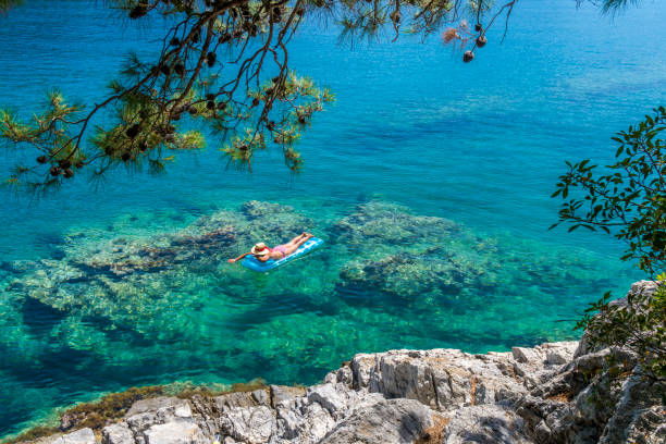 Women is sunbathing on the seabed.