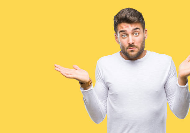 istock Young handsome man over isolated background clueless and confused expression with arms and hands raised. Doubt concept. 1046566148