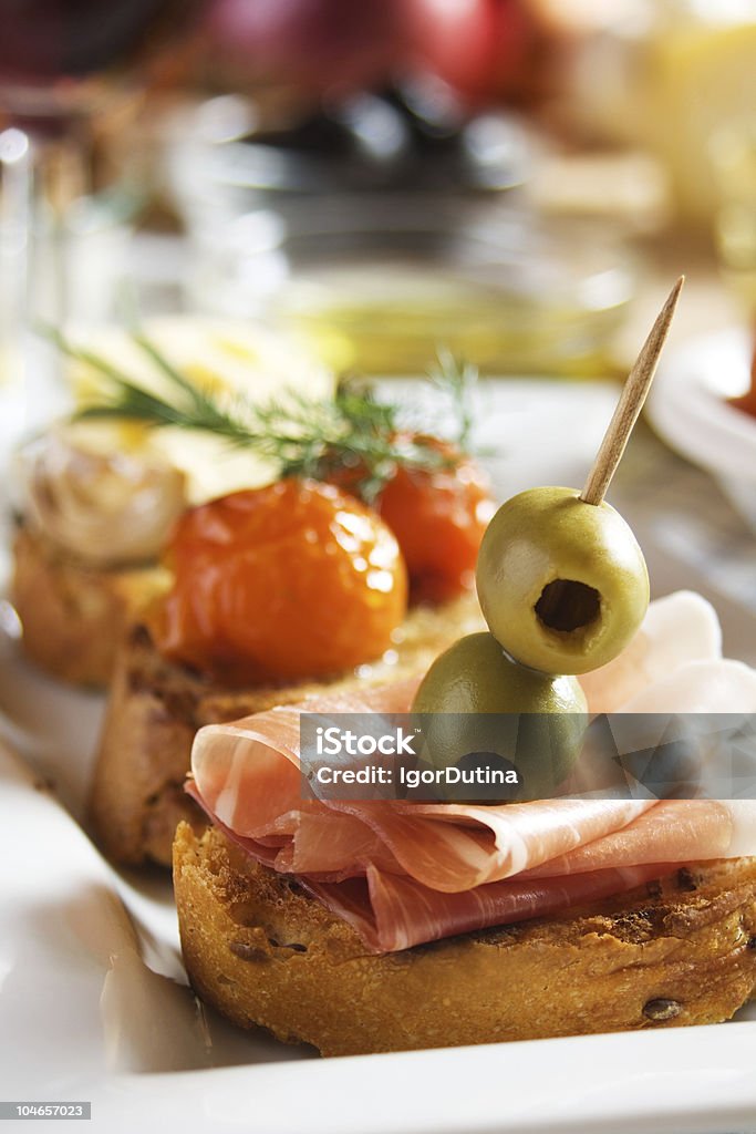 Bruschetta con prosciutto e olive - Foto stock royalty-free di Antipasto