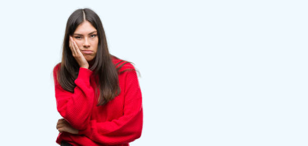 istock Young beautiful hispanic wearing red sweater thinking looking tired and bored with depression problems with crossed arms. 1046570340