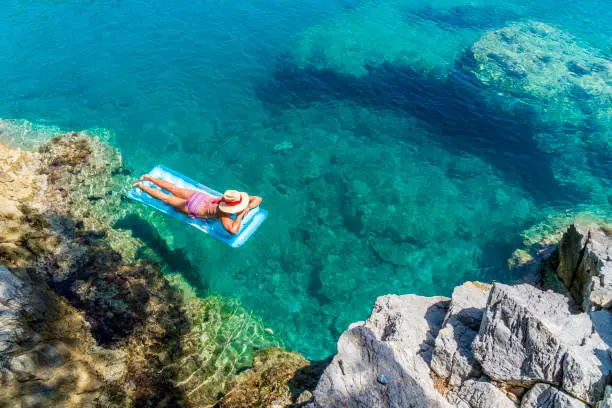 Women is sunbathing on the seabed.