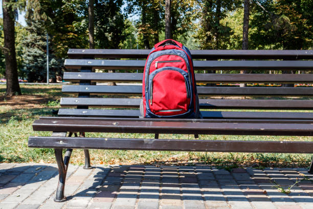 istock Backpack on wooden bench in city park 1046577968