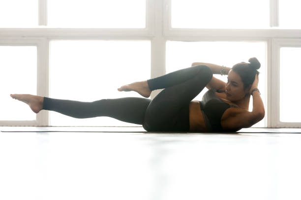istock Young sporty woman practicing, doing crisscross exercise 1046581224