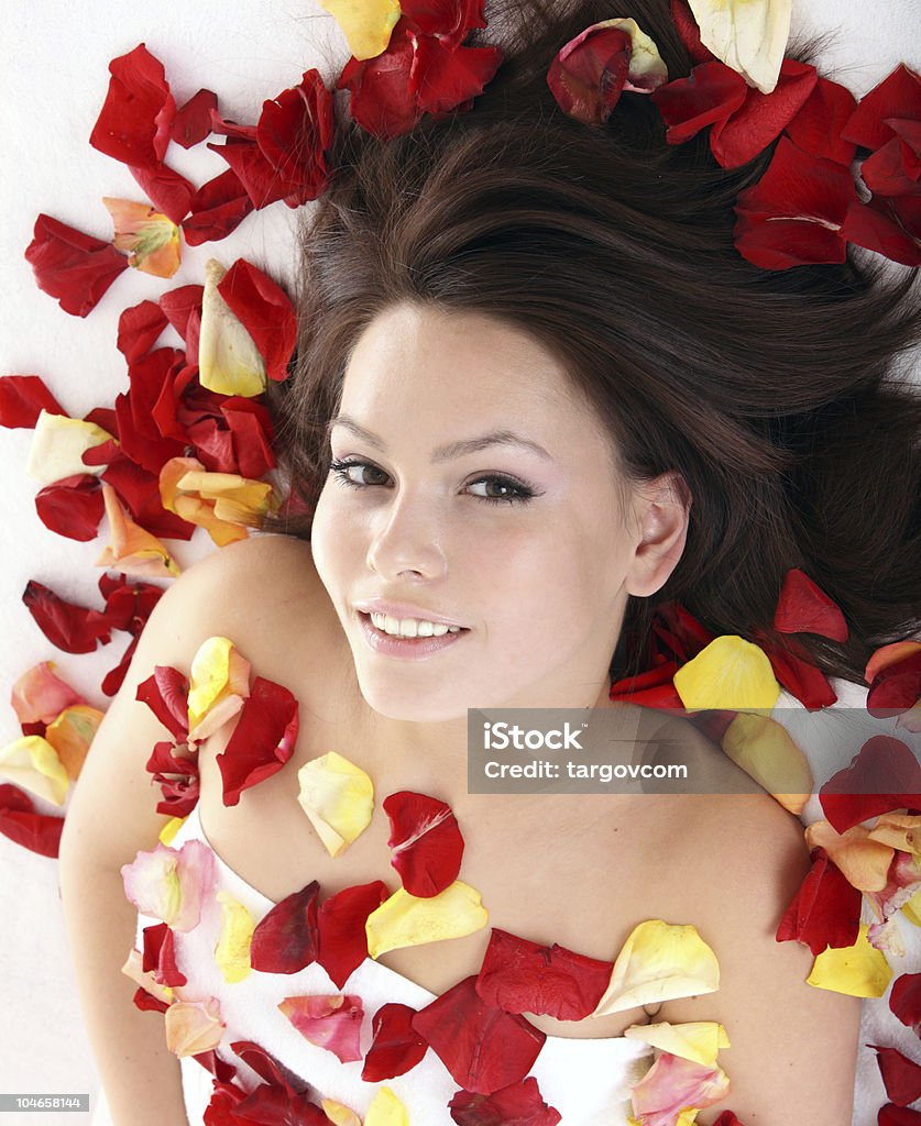 Beautiful girl in rose petal. Spa.  Adult Stock Photo