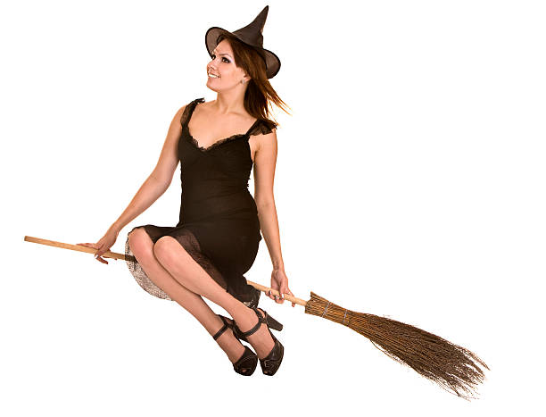 A young witch with jack o'lantern in a night misty forest. Smiling attractive woman with a carved pumpkin and smoke. Halloween party, trick or treat concept. Magic, witchcraft, sorcery. Banner with copy space