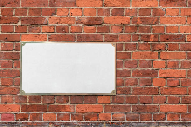 istock Mock up with empty blank white address sign on a brick wall 1046583488