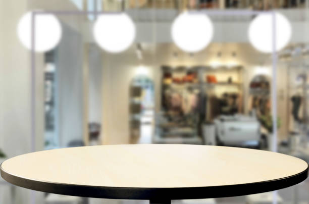 Empty dining table top with defocused pendant lamps background. Ideal for product image display