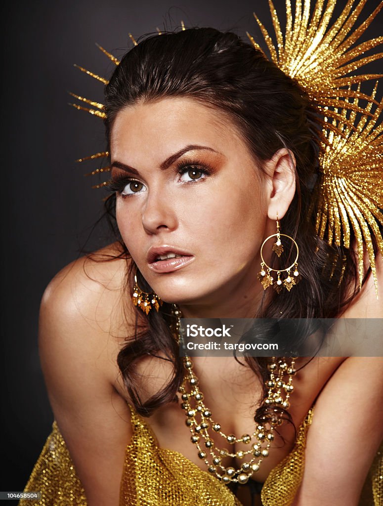 Bellissima giovane donna in oro su sfondo grigio. - Foto stock royalty-free di Adulto