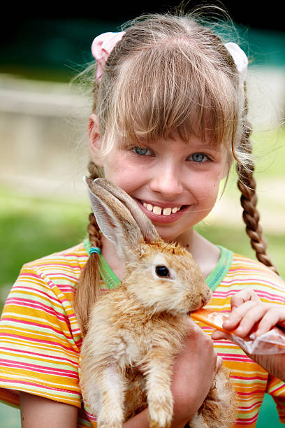 istock Happy girl feed rabbit with carrot. 104658651
