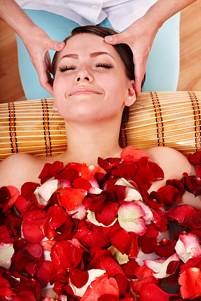 hermosa chica en el jacuzzi con rosa pétalos en. - head massage massaging facial massage beautician fotografías e imágenes de stock