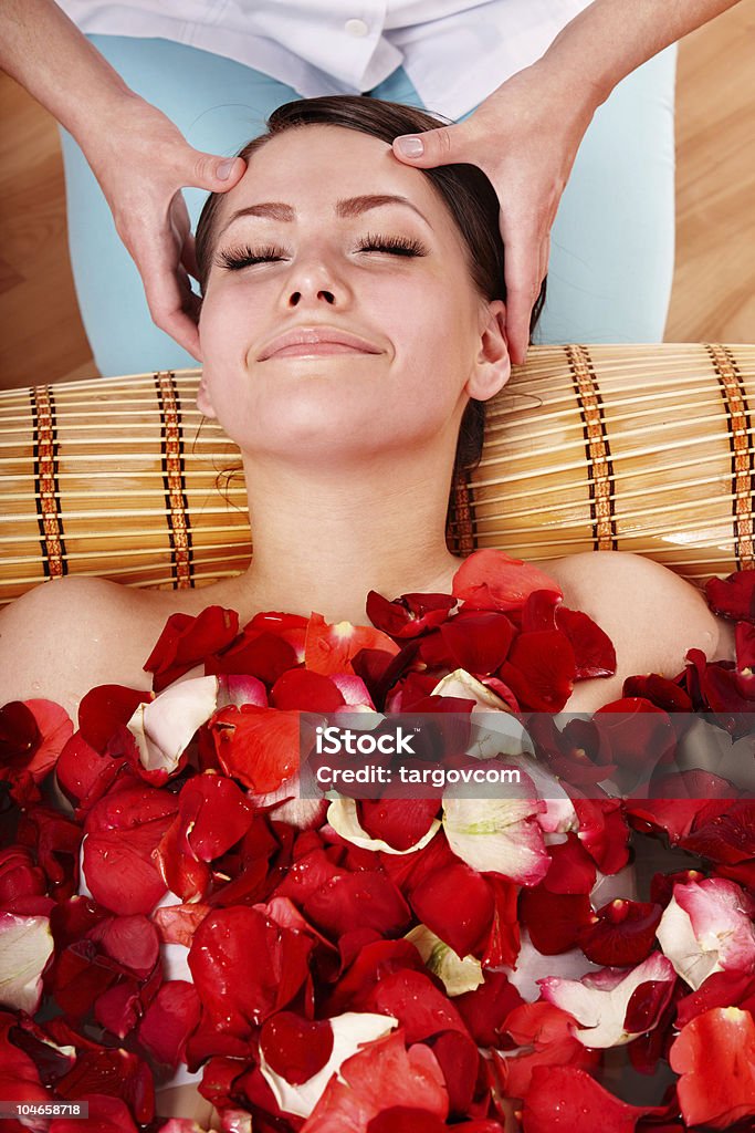 Linda menina com banheira de hidromassagem com pétalas de rosa. - Foto de stock de Flor royalty-free