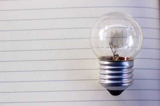 istock Close-Up Of Light Bulb On Notebook 1046594808