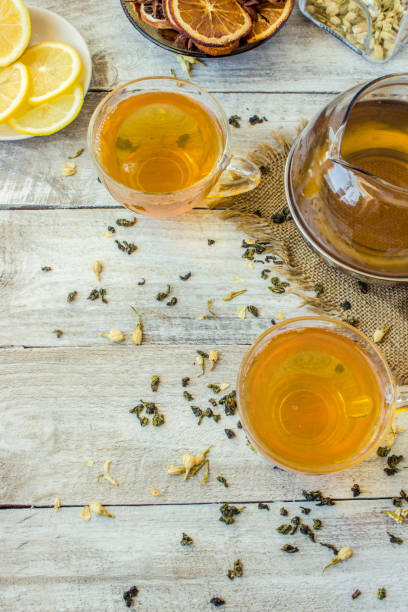 istock Green tea with Jasmine and black with transparent lemon in a small Cup on a light background. The tea maker. Selective focus. 1046599390