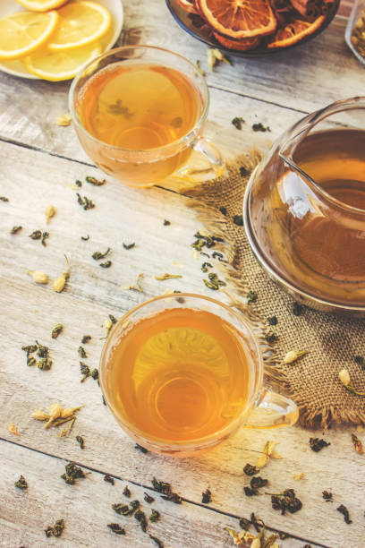 istock Green tea with Jasmine and black with transparent lemon in a small Cup on a light background. The tea maker. Selective focus. 1046599394
